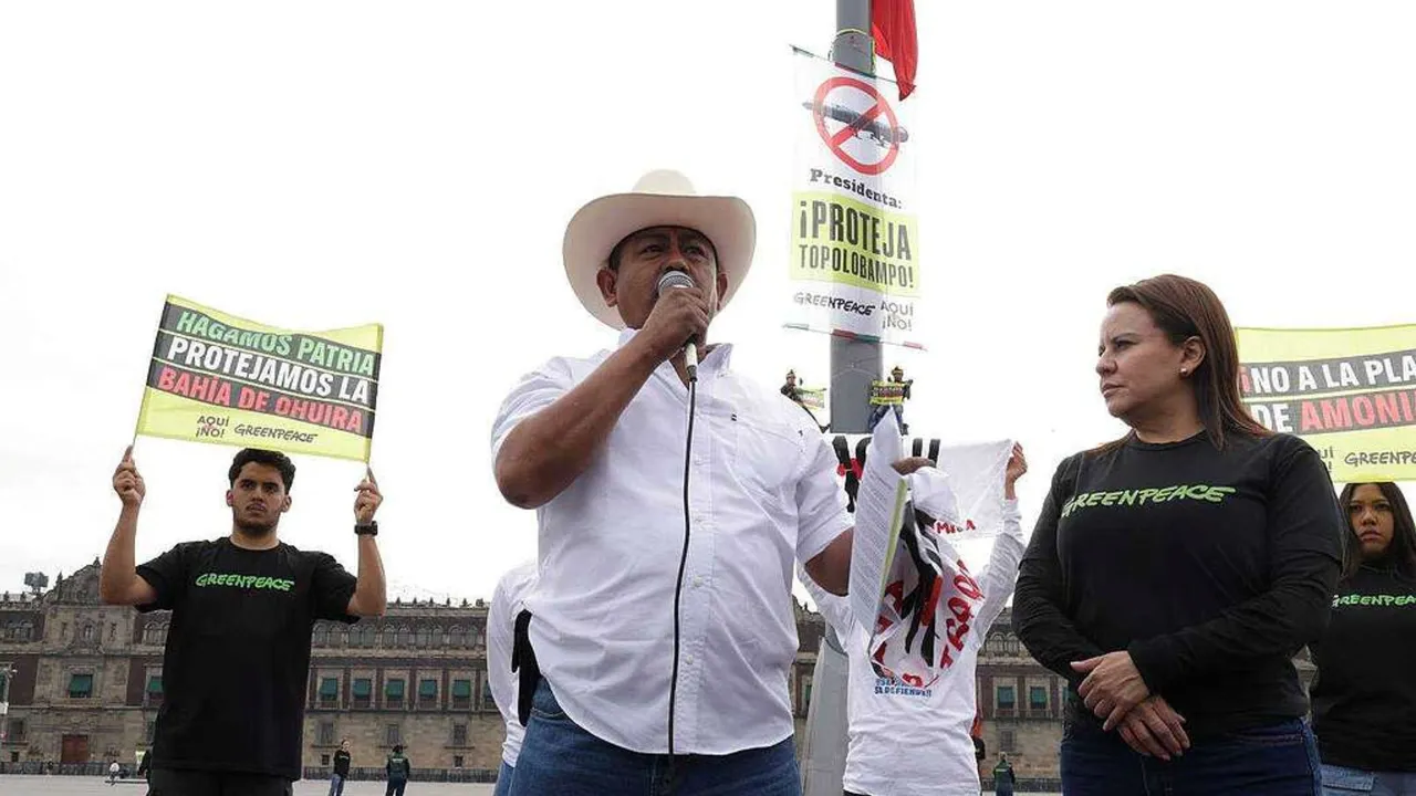 Activistas escalan asta bandera del Zócalo para exigir freno a planta de amoníaco en Topolobampo