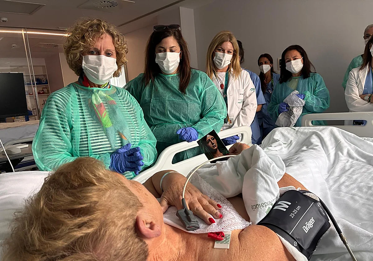 Camareras de la Esperanza reparten pañuelos de la Virgen entre los enfermos del Hospital Clínico